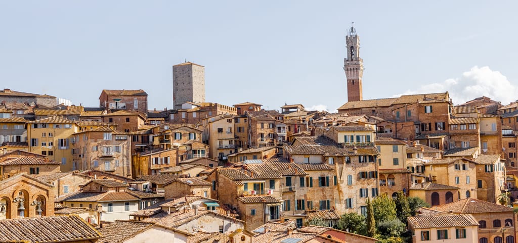 Cityscape of Siena town with bell tower of town hall in Tuscany region of Italy. Concept of visiting italian landmarks