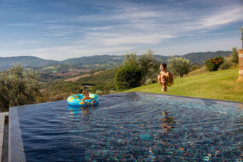 Kids jumping on pool at Casali Di Casole during the sunner