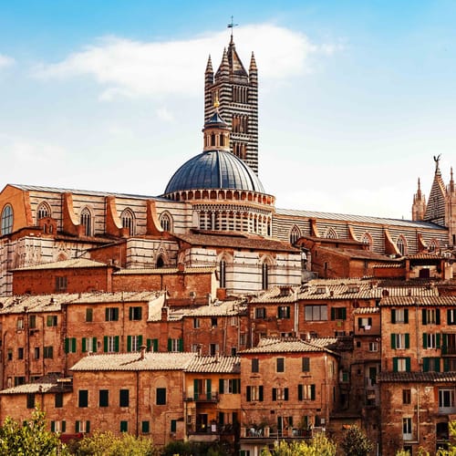 View of building in center of Siena, Italy with Cathedral of Santa Maria Assunta in background