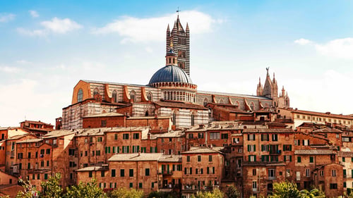 View of building in center of Siena, Italy with Cathedral of Santa Maria Assunta in background