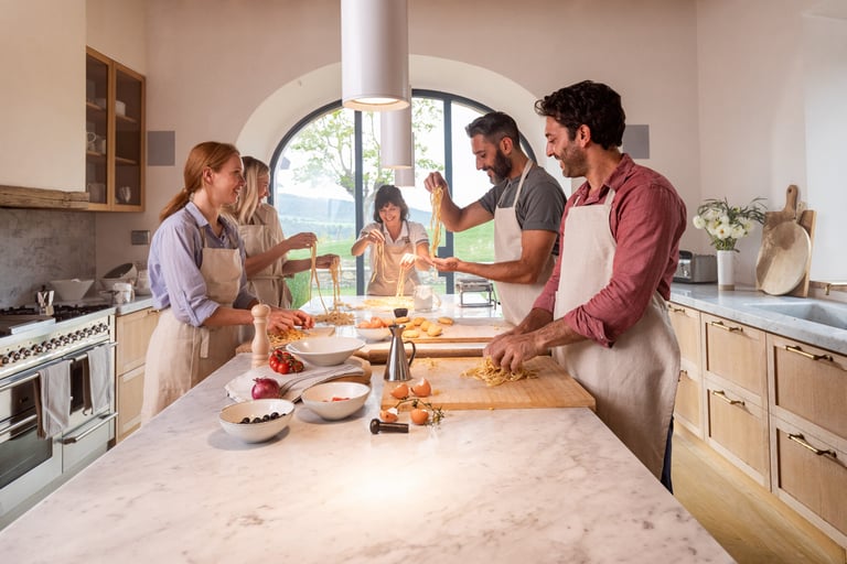 Family enjoying cooking class in farmhouse at Casali di Casole, Tuscany, Italy.